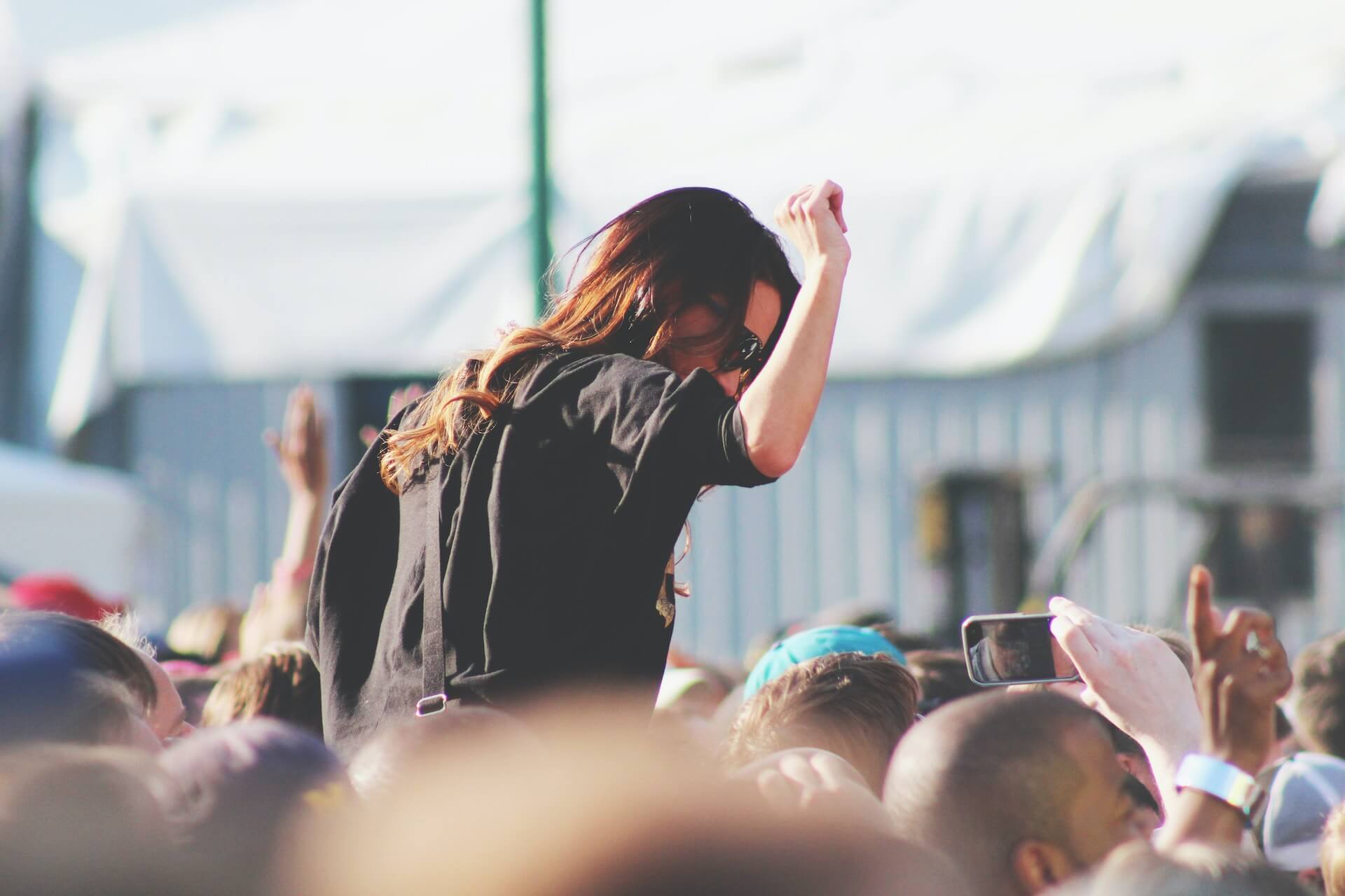 Woman in the crowd at concert. Photo credit Joey Thompson, Unsplash